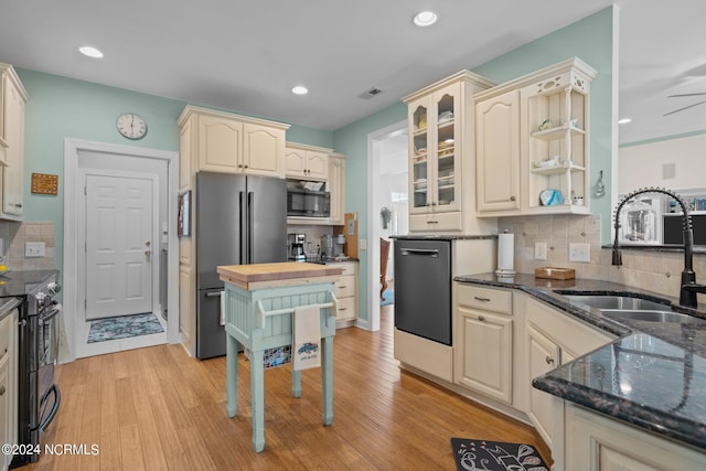 kitchen with stainless steel appliances, light hardwood / wood-style flooring, tasteful backsplash, and sink