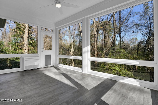 unfurnished sunroom featuring ceiling fan and plenty of natural light