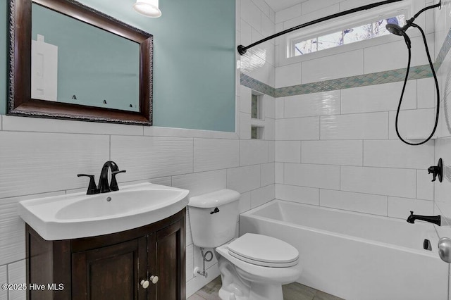 full bathroom with tiled shower / bath, vanity, tile walls, and toilet