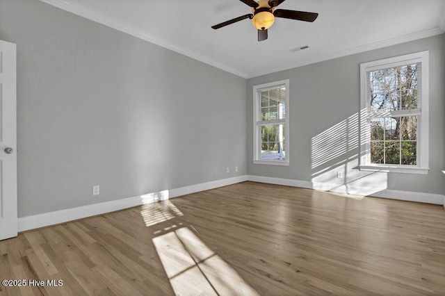 spare room featuring a healthy amount of sunlight, light wood-type flooring, and crown molding