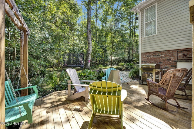 deck featuring a grill and a trampoline