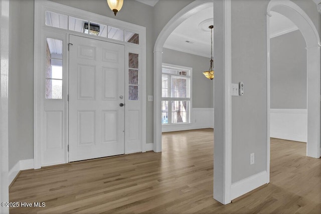 foyer with plenty of natural light, light hardwood / wood-style floors, and ornamental molding