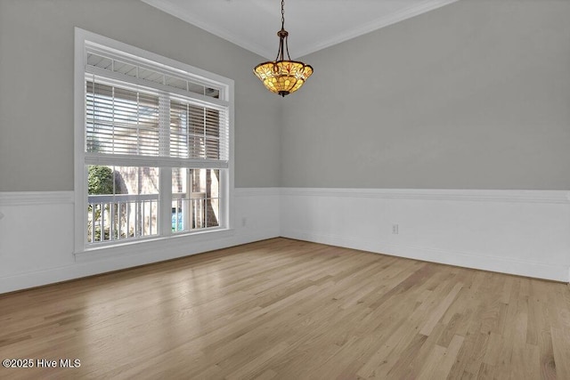 empty room with light hardwood / wood-style floors and crown molding