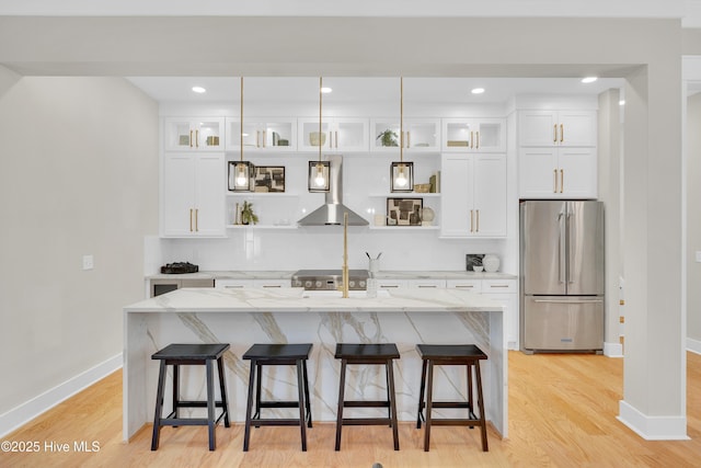 kitchen with a kitchen island with sink, island range hood, white cabinets, and appliances with stainless steel finishes