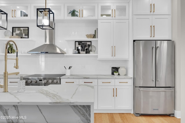 kitchen with light stone counters, white cabinets, and stainless steel refrigerator