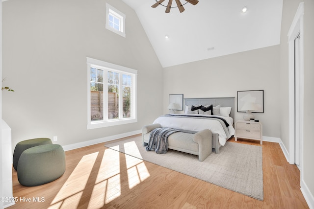 bedroom with high vaulted ceiling and light wood-type flooring