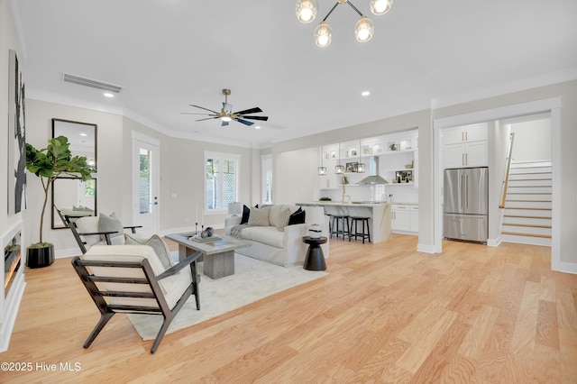 living room with crown molding, light hardwood / wood-style floors, and ceiling fan