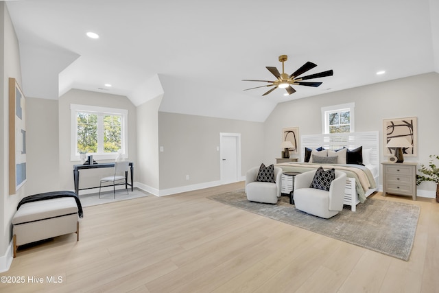 bedroom with multiple windows, vaulted ceiling, ceiling fan, and light wood-type flooring