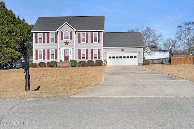 colonial home featuring a front lawn and a garage