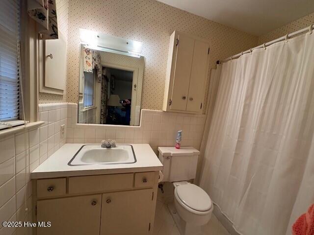 bathroom with vanity, toilet, backsplash, and walk in shower