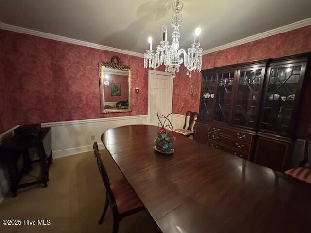 dining room with ornamental molding and an inviting chandelier