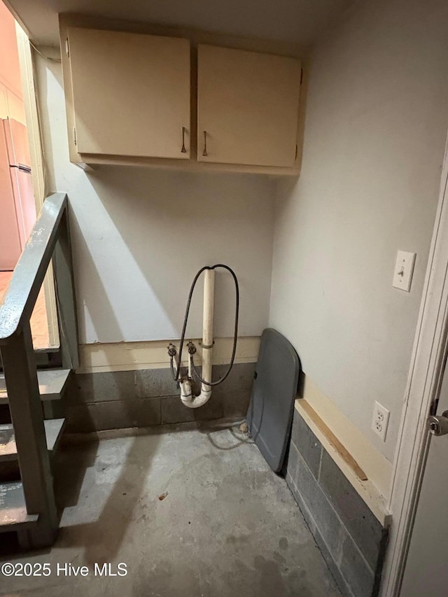 details with white fridge and concrete flooring