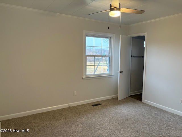 empty room featuring carpet flooring, ceiling fan, and ornamental molding