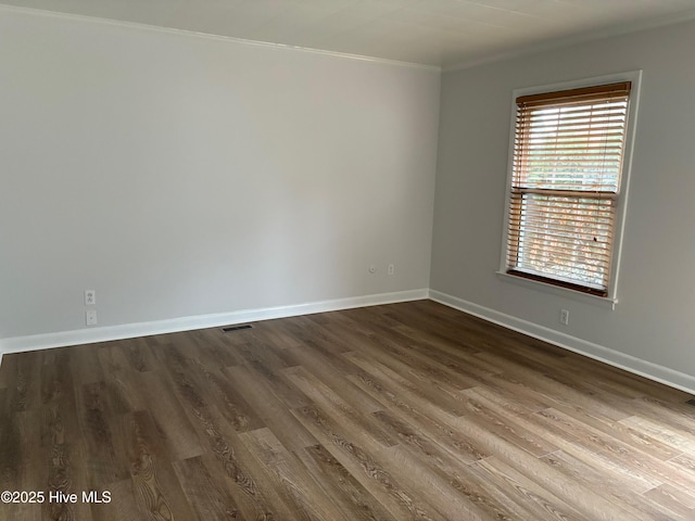 unfurnished room with dark wood-type flooring and ornamental molding