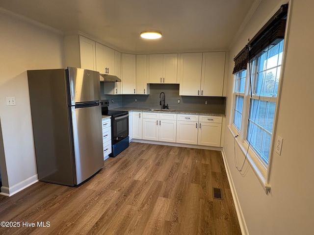 kitchen featuring sink, black electric range, decorative backsplash, white cabinetry, and stainless steel refrigerator