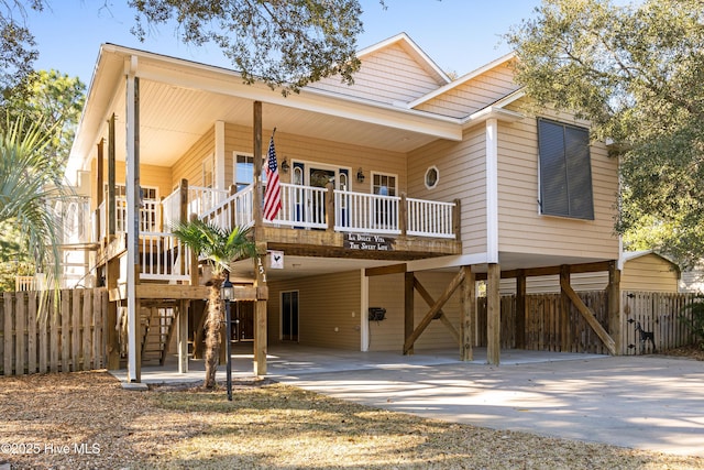 151 NW 8th St, Oak Island, NC 28465 - view of front facade with a carport, concrete driveway, and covered porch