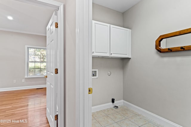 washroom with gas dryer hookup, cabinets, hookup for a washing machine, ornamental molding, and light tile patterned floors