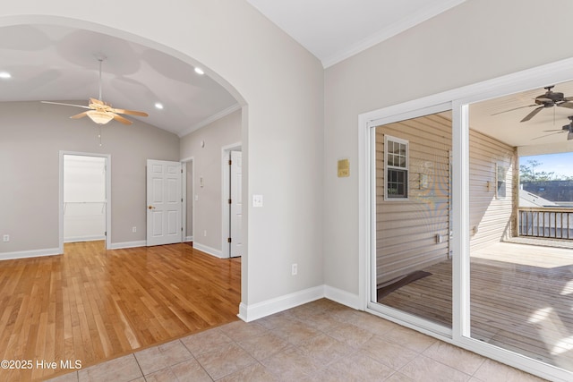 unfurnished room featuring ceiling fan, light tile patterned flooring, ornamental molding, and vaulted ceiling