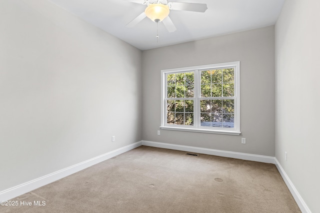 carpeted spare room with ceiling fan