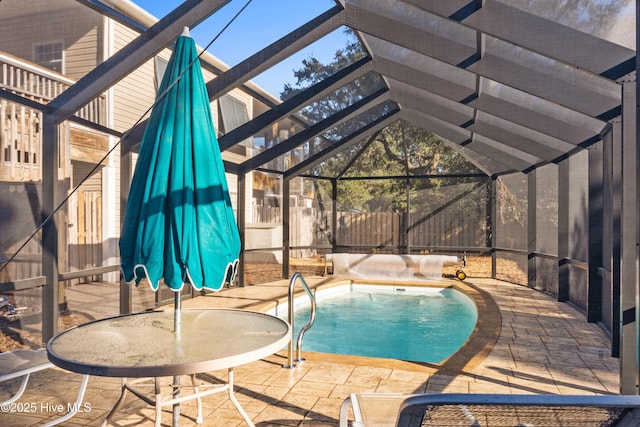 view of pool with a patio area and glass enclosure