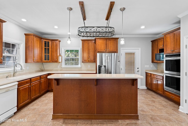 kitchen featuring appliances with stainless steel finishes, a center island, decorative light fixtures, and crown molding