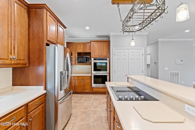 kitchen with decorative backsplash, crown molding, hanging light fixtures, and appliances with stainless steel finishes