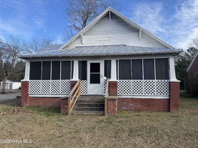 view of front facade featuring a sunroom and a front lawn