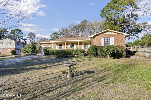 view of front of house featuring a porch, a garage, and a front lawn