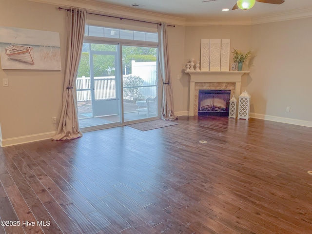 unfurnished living room featuring dark wood-type flooring, ceiling fan, and ornamental molding