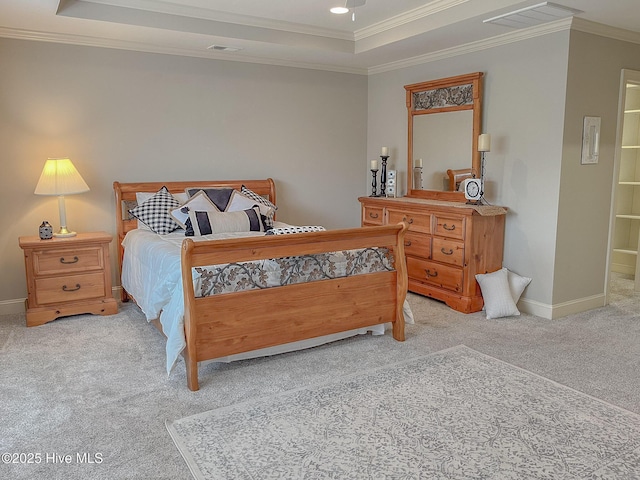 bedroom featuring crown molding, light carpet, and a tray ceiling