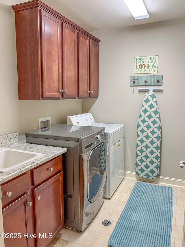 washroom with cabinets, washing machine and clothes dryer, and light tile patterned flooring