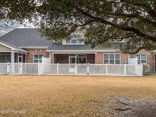 rear view of property featuring a lawn