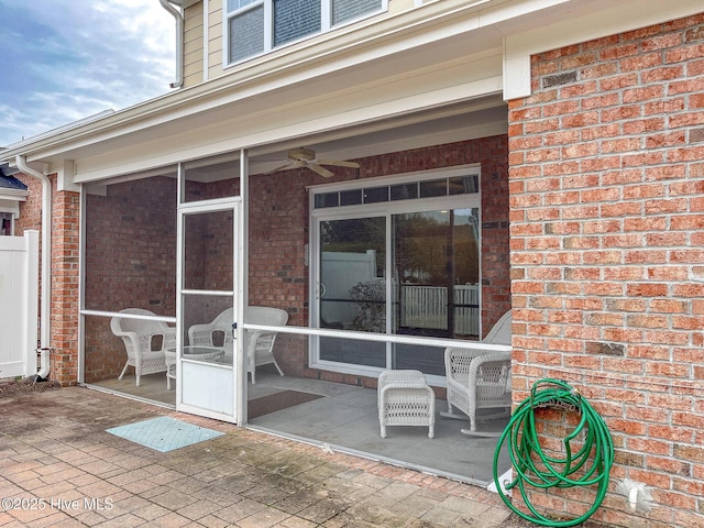 view of patio / terrace with ceiling fan and a sunroom