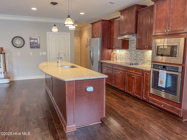 kitchen featuring sink, appliances with stainless steel finishes, an island with sink, light stone countertops, and decorative backsplash