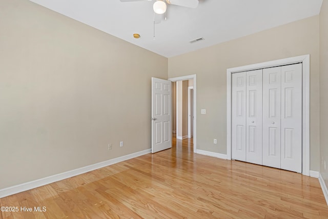 unfurnished bedroom featuring ceiling fan, a closet, and light hardwood / wood-style flooring