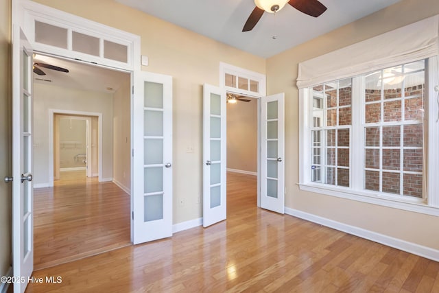 spare room with a healthy amount of sunlight, light hardwood / wood-style floors, and french doors