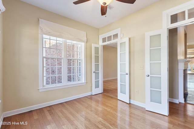 spare room with light hardwood / wood-style floors, ceiling fan, and french doors