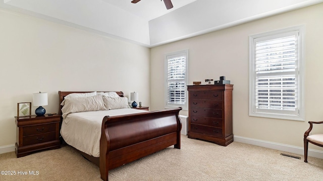 carpeted bedroom with ceiling fan and a tray ceiling