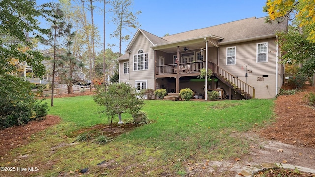 back of property featuring ceiling fan and a yard