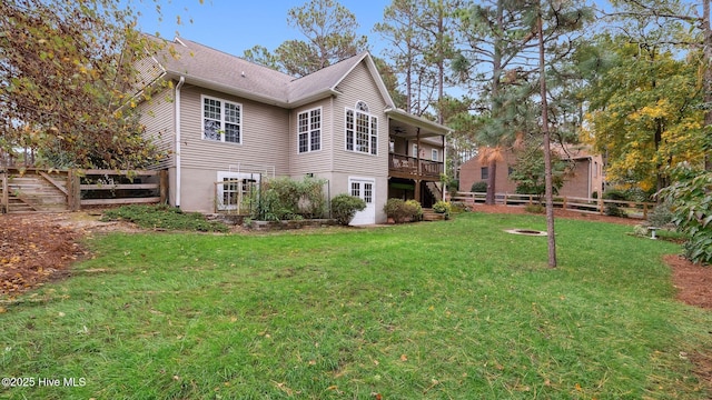 view of side of property featuring ceiling fan, a yard, and a deck