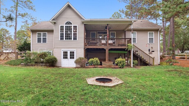 rear view of property with an outdoor fire pit, a yard, ceiling fan, and a wooden deck