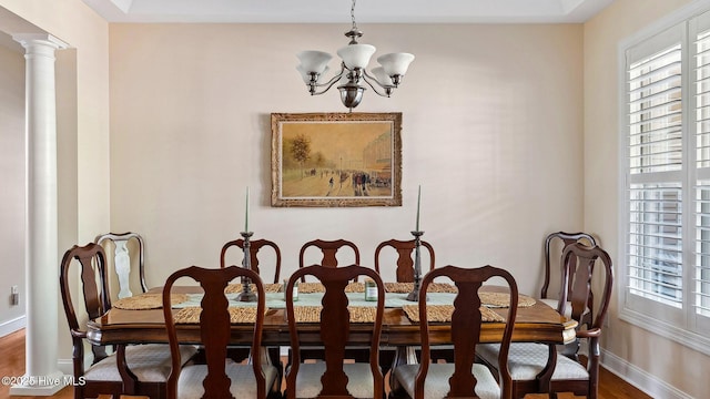 dining room with decorative columns, a chandelier, and wood-type flooring