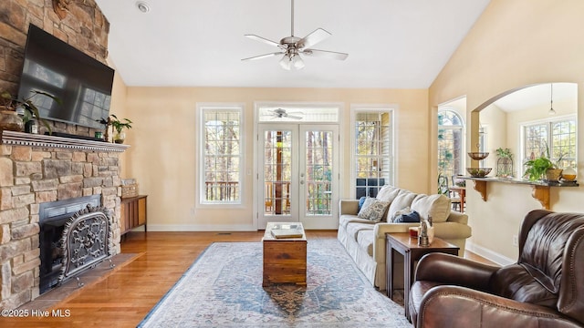 interior space featuring ceiling fan, a stone fireplace, and lofted ceiling