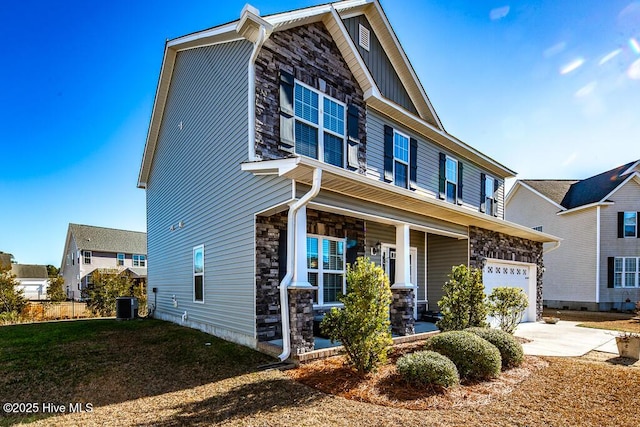 craftsman house featuring central air condition unit, stone siding, covered porch, and concrete driveway