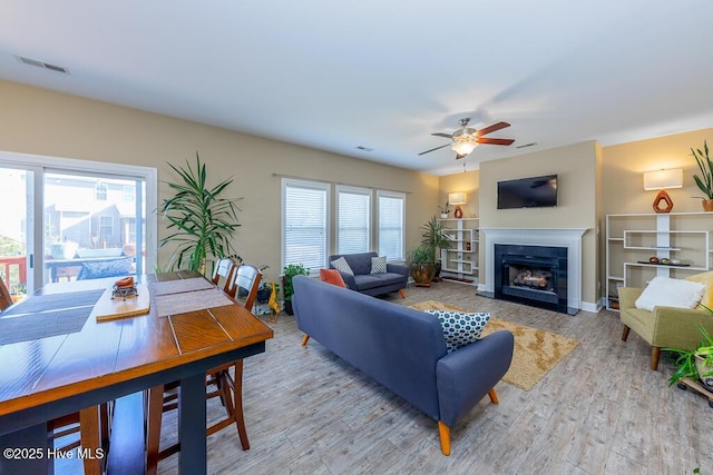 living room featuring light hardwood / wood-style floors and ceiling fan