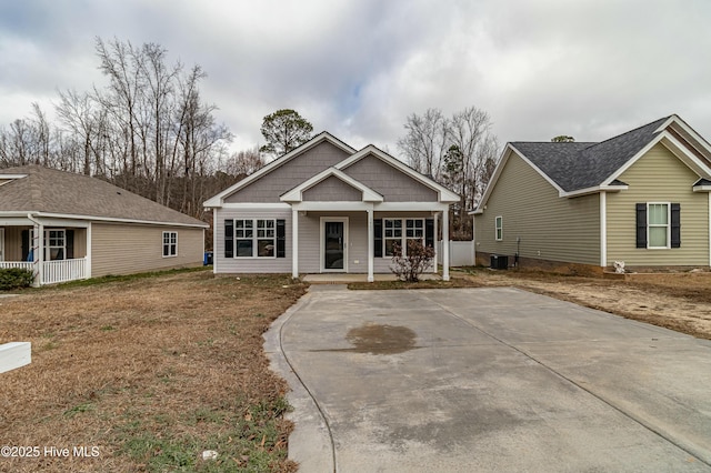 view of front of house with central air condition unit, a porch, and a front yard