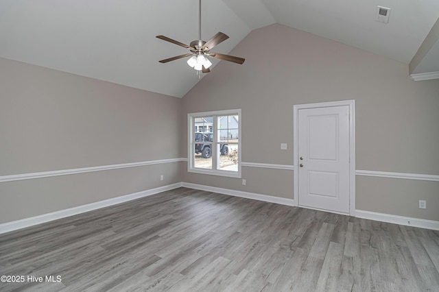 empty room featuring ceiling fan, vaulted ceiling, and light wood-type flooring