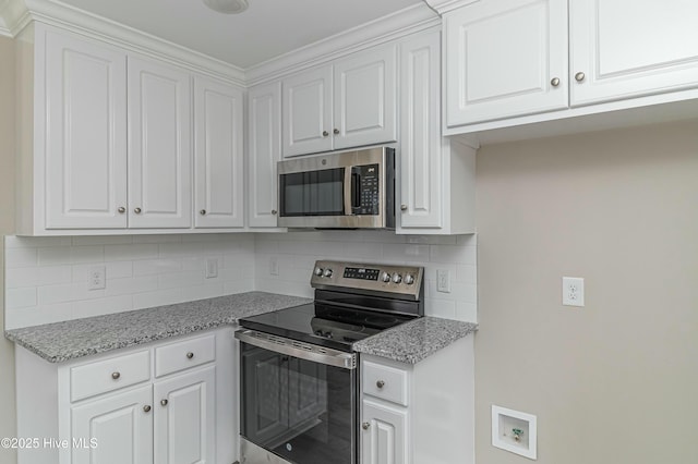 kitchen with backsplash, white cabinets, and stainless steel appliances