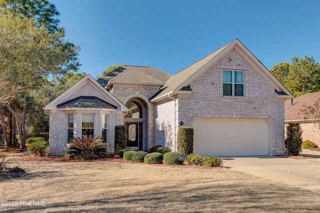 view of front of home with brick siding, concrete driveway, and a garage
