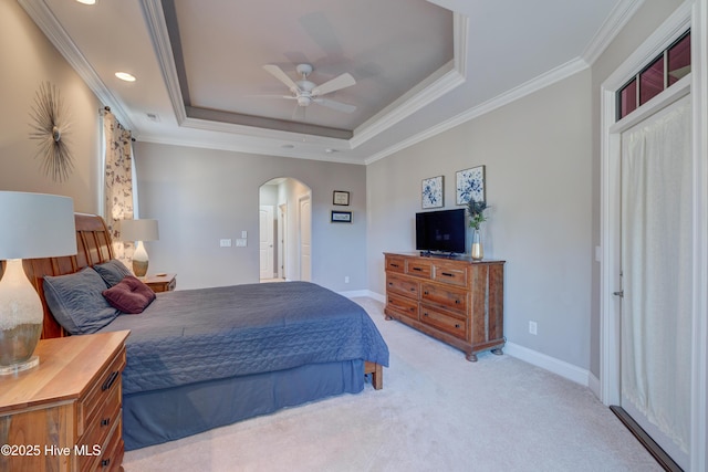 carpeted bedroom with crown molding, a raised ceiling, and ceiling fan